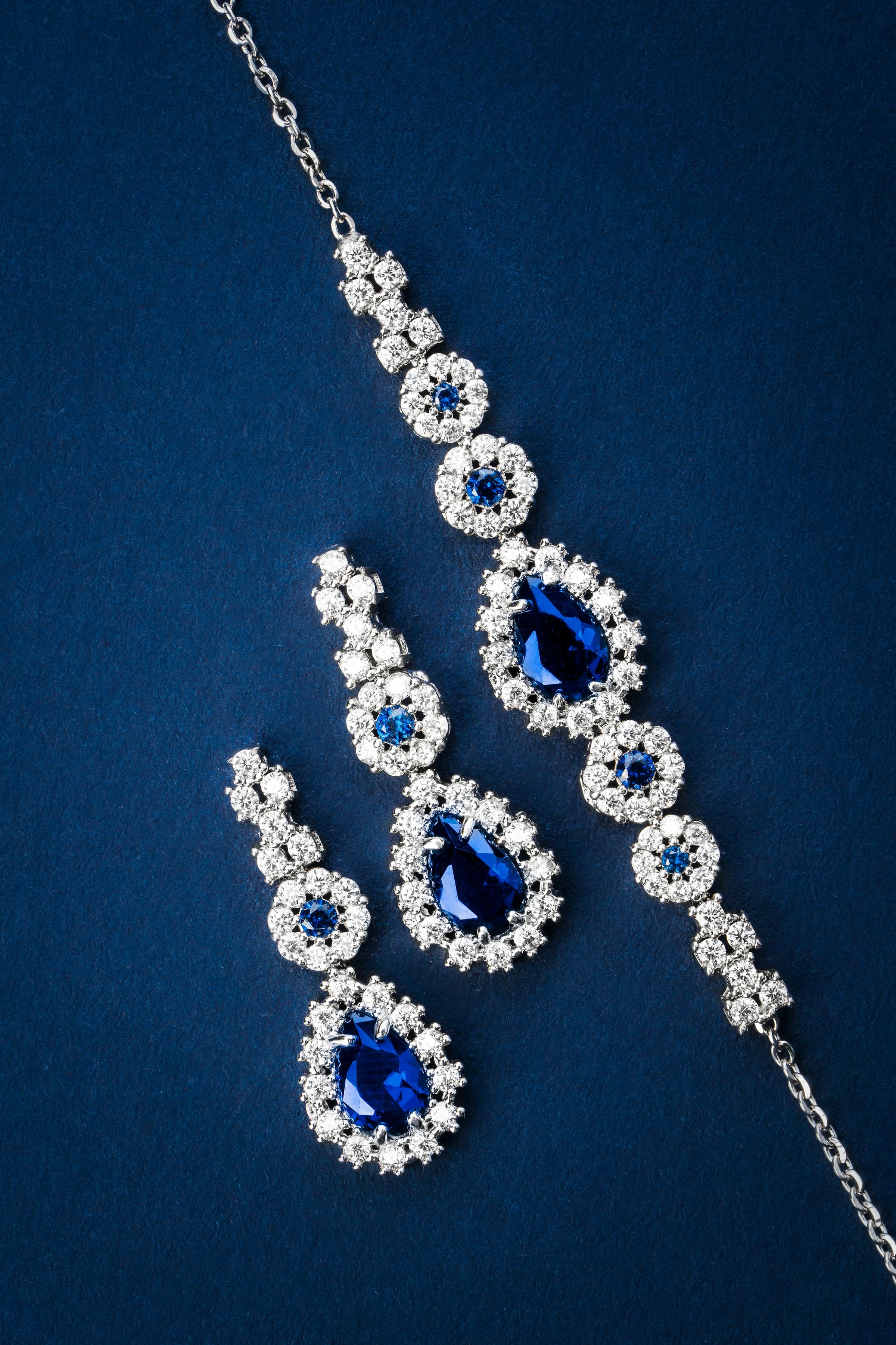 Blue sapphire and diamond necklace and earrings on navy velvet